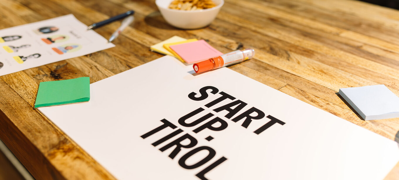 Postits, Kugelschreiber, Stifte liegen auf einem Holztisch