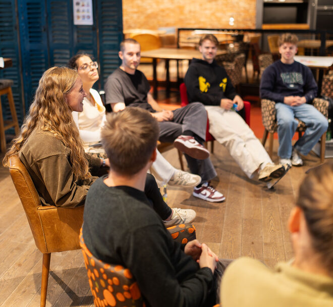 Mehrere Personen sitzen auf den Stühlen im Kreis